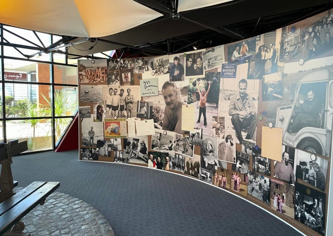 Vue du murs de photographies avec Georges Brassens et baie vitrée sur l'étang de Thau