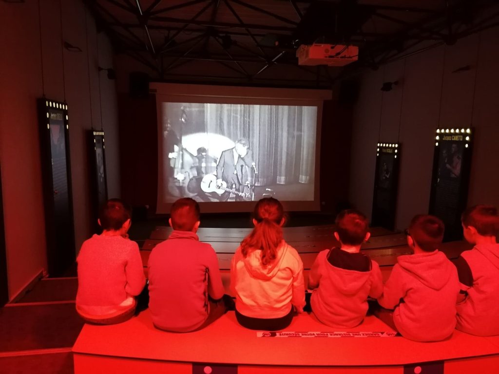 Enfants de dos dans l'auditorium de l'Espace Georges Brassens