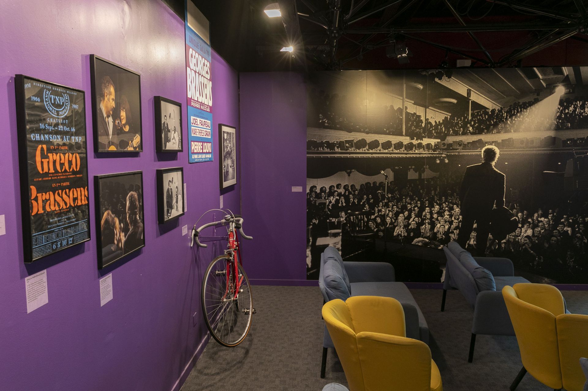 Vue de la scénographie avec photographies et vélo rouge ayant appartenu à Georges Brassens