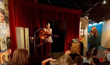 Photo d'une jeune fille sur scène avec une guitare