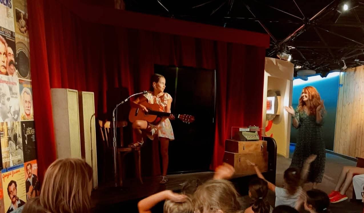Photo d'une jeune fille sur scène avec une guitare