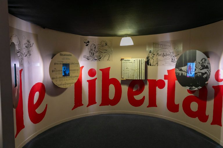Vue de la scénographie avec écriture en rouge le Libertaire