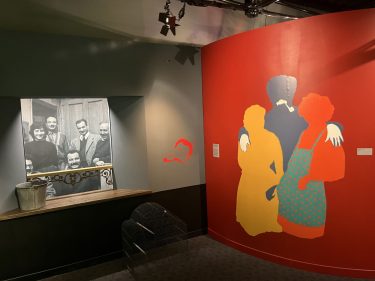 Scénographie avec photographie de l'Impasse Florimont et illustration représentant Georges Brassens entouré de 2 femmes.